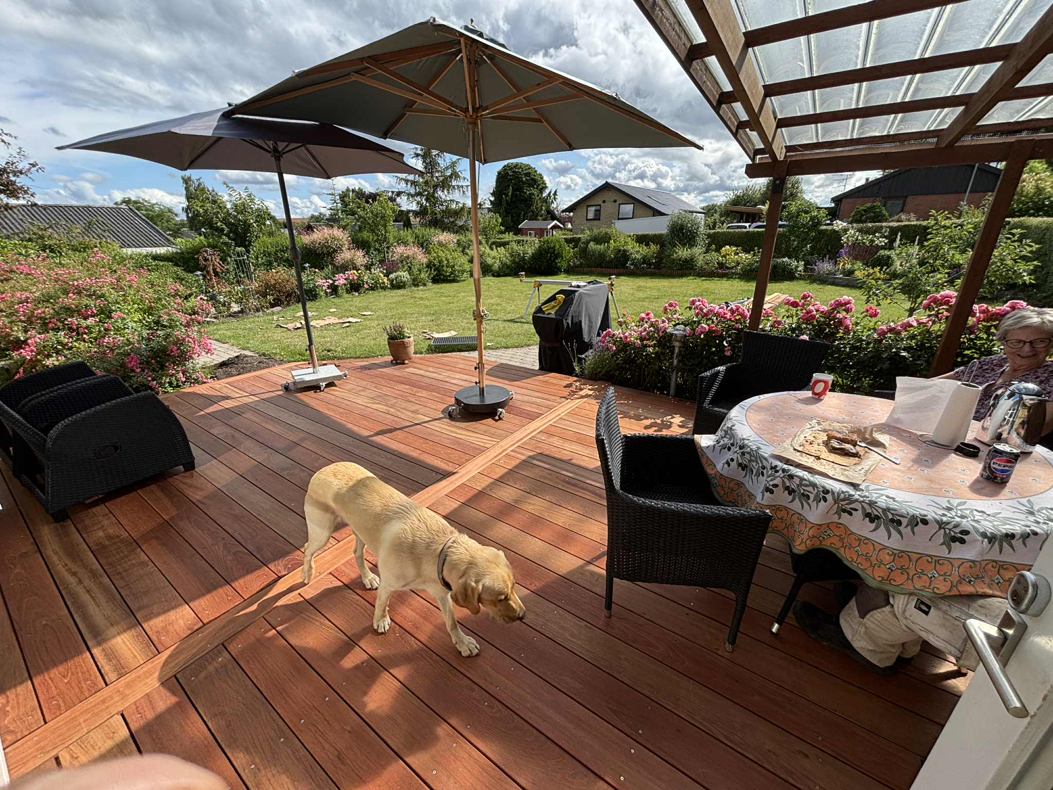 Overdækket træterrasse med havemøbler og parasol